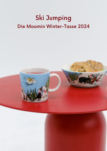 Die saisonale Moomin Tasse mit der Schale 2024. Das Motiv heißt Ski Jumping.