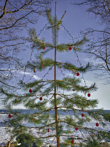 Ein Weihnachtsbaum vor der eiskalten, weiß-blauen Natur im Norden, das bedeutet für Marimekko stimmungsvolle Weihnachten. 